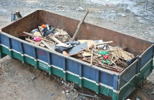 Construction site with builders clearing waste in Balham